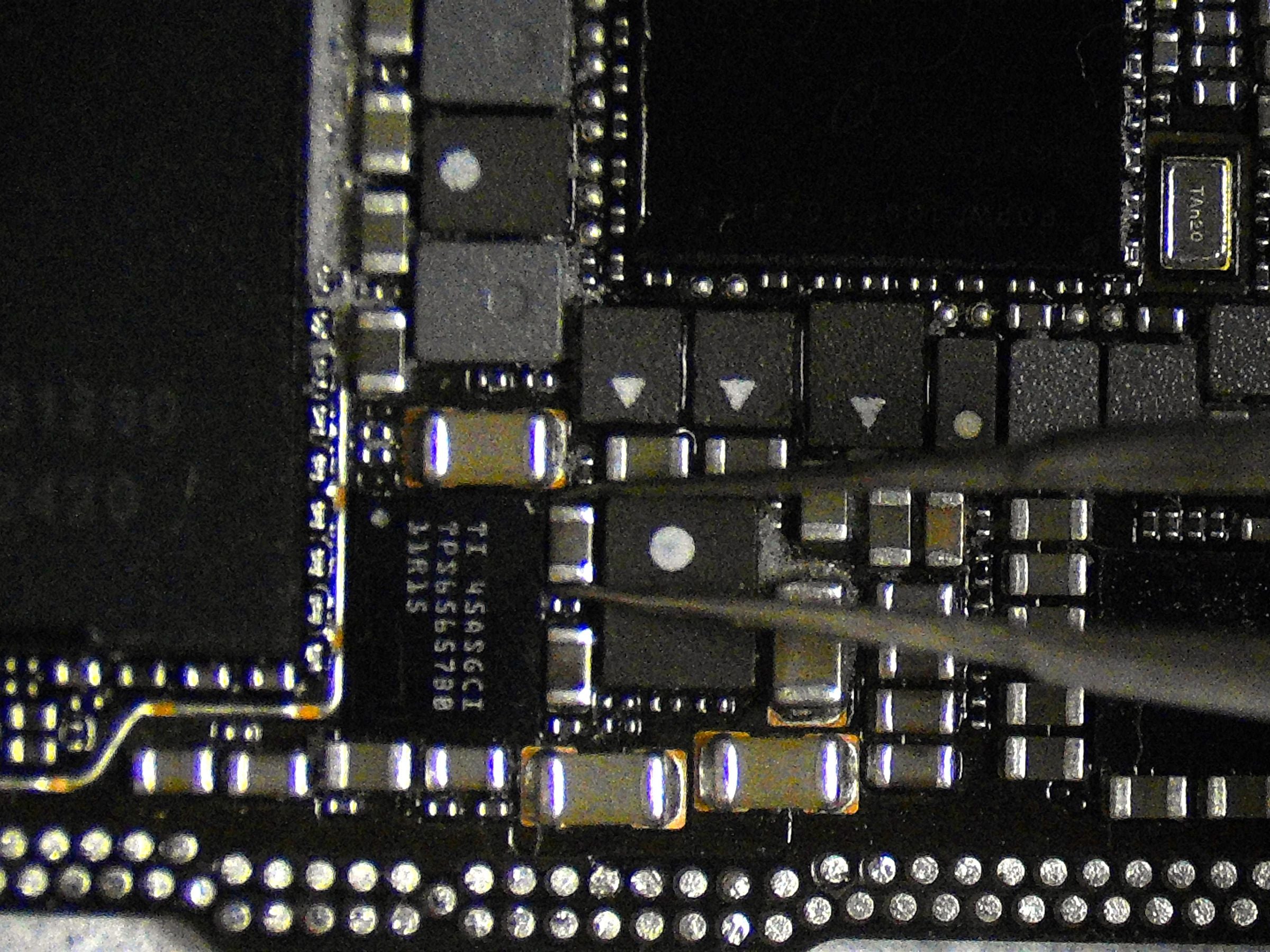 Close-up of a circuit board with electronic components under the microscope for microsoldering repair at Phone Fact in Hamilton.