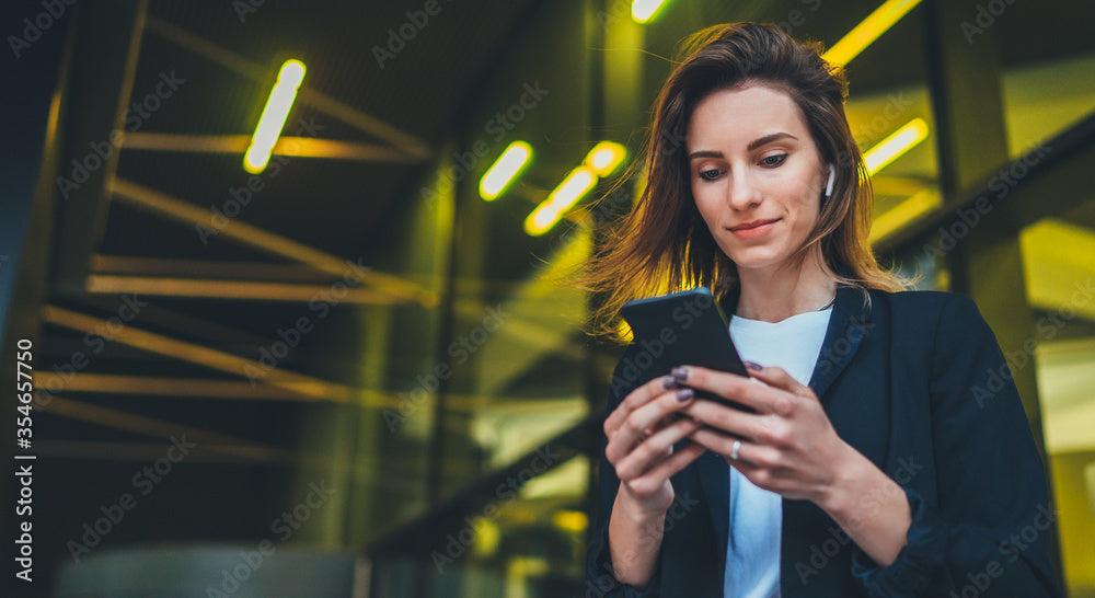 A woman looking at her refurbished phone